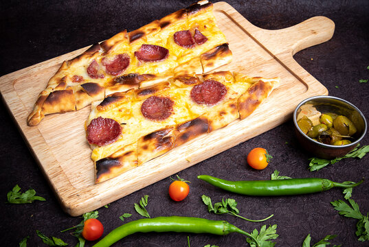 Kaşarlı Sucuklu Pide, Turkish or traditional pita with sujuk and cheese. Turkish pide dish with slices of beef, tomatoes and halal sausage sujuk.