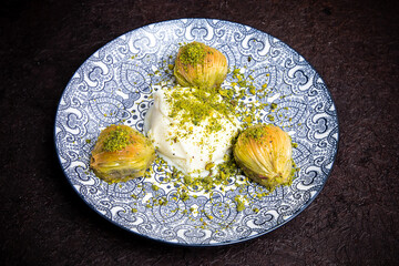 Delicious Turkish baklava served with pistachio cream and cream ice cream on a plate. Turkish Ramadan Dessert Baklava kadayif with ice cream concept background