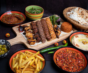 Arabic grilled arabic food dishes kebab, dolma, mansaf, shawarma Turkish and Arabic Traditional Ramadan Mix Vali Kebab Plate inside Adana, Urfa, Chicken, Lamb, Liver and Beef on bread on table