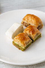 Traditional Turkish dessert pistachio baklava on a white porcelain plate