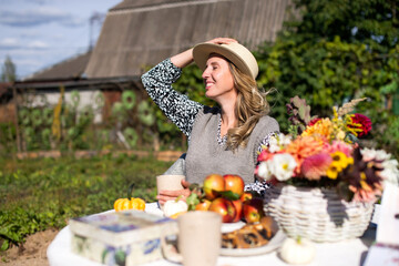 Fototapeta premium A happy girl in a straw hat is sitting on a picnic