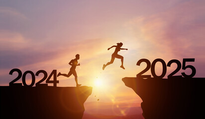 New Year 2025, Inspiration and progress towards new success. Silhouettes of human jumping over...