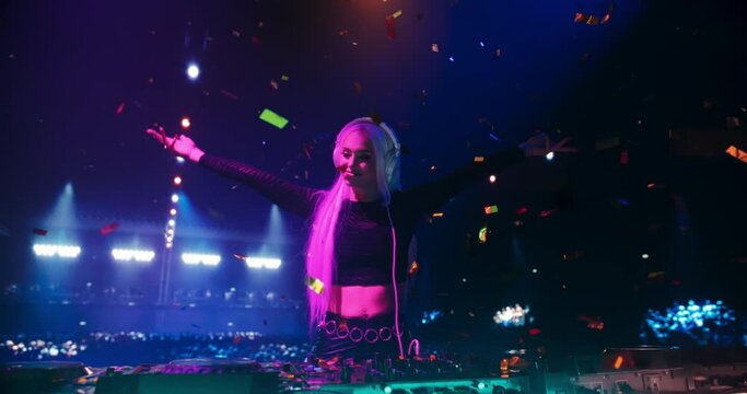Female DJ Delivers a Mesmerizing Live Electronic Music Performance. Caucasian Young Woman Using Turntables at a Massive Concert. Colorful Lights, Confetti and Dance Beats at an EDM Concert