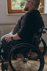 Obraz premium A young man sitting in a chair looking out the window