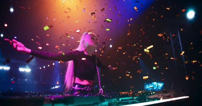 Creative Female DJ Energizing the Nightclub with Her Electronic Dance Music Performance. Pulsating Lights, Confetti and Beats Create an Energetic Atmosphere in the Club. Cinematic Footage