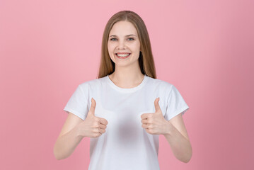Attractive caucasian young blonde woman in casual white t-shirt smiling, looking at camera and...