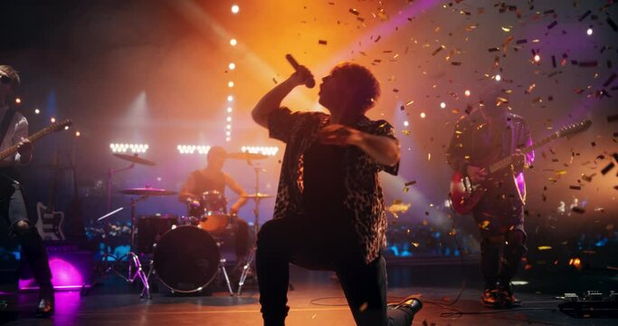 Young Indie Band Playing a Rock Music Gig with Alternative Punk Tracks at a Festival with Energetic Music Fans. Five Charismatic Musicians Make a Live Performance Under Falling Confetti