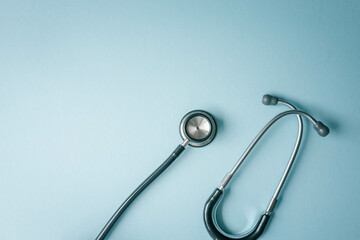 Stethoscope on blue background, top view. Space for text