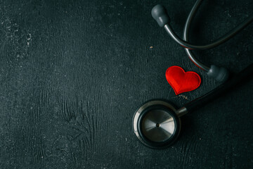 Stethoscope on black background, top view. Space for text