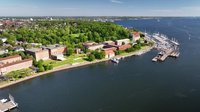 Aerial view of Kiel Harbor's inner fjord, the Schleswig-Holstein Landtag building, the Kiellinie promenade and marinas with moored sailing boats. Aerial footage of Kiel inner Fjord, Kiel bay.