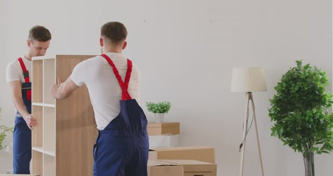 Two heavy men movers delivery furniture in boxes to new house. Working with precision and care movers delivery furniture handle each item ensuring safe delivery furniture New start of new house