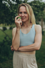 Fototapeta premium Apple woman. Very beautiful ethnic model eating green apple in the park.