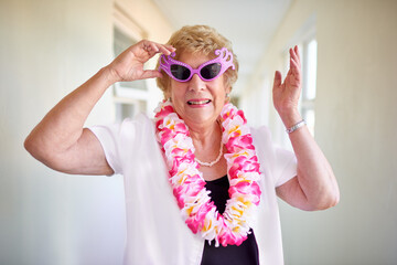 Face, smile and sunglasses with senior woman in hallway of retirement home for goofy party on weekend. Portrait, funny and eyewear with happy mature person laughing at joke in elder care apartment