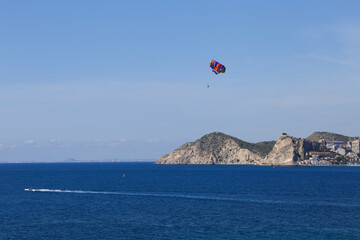 People parascending on Benidorm beach under blue sky