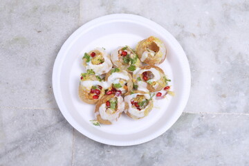 A plate of traditional Indian or Pakistani appetizer Dahi Puri, crispy shells stuffed with boiled potatoes and spices