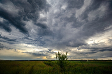 Dark stormy clouds over a country road, summer time