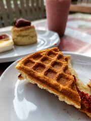 Crunchy waflle with strawberry filling on a white plate. Cafe restaurant setting.
