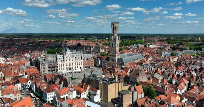 Belfry of Bruges, Belgium, June 2024. Drone orbits aerial view of Bruges cityscape and Belgium&rsquo;s landscape, highlighting the Medieval belfry tower.
