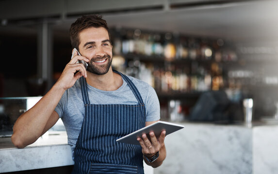 Happy man, waiter and phone call with tablet for online order, conversation or discussion at indoor cafe. Male person or barista talking with smile or technology on mobile smartphone for reservation