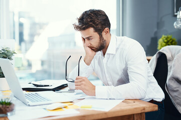 Office, laptop and man with headache by desk for tension, pain and brain fog in accounting job....