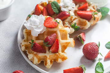 Belgian waffles with fresh strawberries in a plate. Viennese waffles