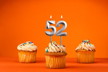 Candle number 52 - Celebration with birthday cupcake on orange background