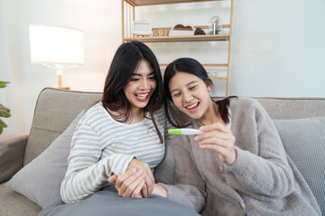 Obraz premium Happy LGBT Couple Celebrating Positive Pregnancy Test Result at Home, Embracing Parenthood and Love, Modern Family Lifestyle, Joyful Moment, LGBTQ Community