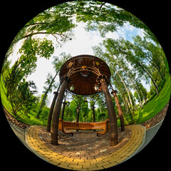 Fisheye view of a gazebo with a bench in the garden or park. Circular photo 180°. Wide-angle round...