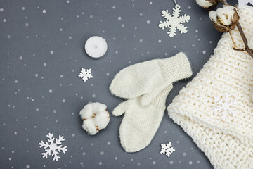 Cozy winter composition. Knitted mittens, warm scarf, traditional Christmas decoration