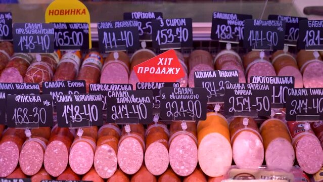 Sumy, Ukraine - December 21, 2023: Meat products store. Sausages on display at a grocery store. Sausage price tags.