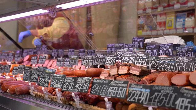 Sumy, Ukraine - December 21, 2023: Meat products store. Sausages on display at a grocery store. Sausage price tags.