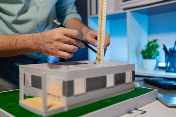 an architect is working in the office, an engineer works on house model on the desk, he used his expertise skill and creativity to design the best work for the client