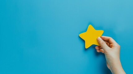 A Hand Gently Holding a Yellow Star-Shaped Object Against a Bright Blue Background.