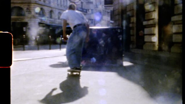 Professional skateboarder riding . Back view of skater boy enjoying summer outdoors. Shoot on 8mm camera