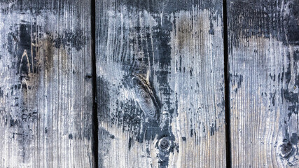 Old wooden black wall with peeling paint