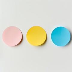 Three circular sticky notes in yellow, pink, and blue placed centrally on a white background.