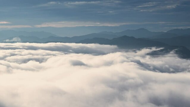 Before sunrise, the unpredictable sea of ​​clouds is like turbulent waves. View of the mountains surrounding Emerald Reservoir. Xindian District, Taiwan.