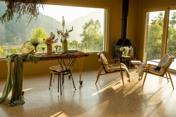 Interior of a beautiful house in natural style with a fireplace and panoramic window with great view on mountains