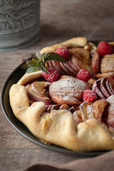 Apple galette with berries and sugar powder on the plate 