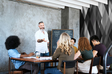 Man, mentor and chalk board in office for training, teaching and learning for skill or career development. People, employee and leader with teamwork or collaboration for internship and coach program
