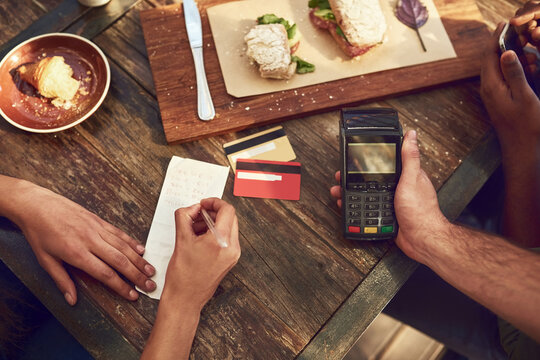 Hands, food and restaurant for payment with credit card, machine and bill for lunch or meal in cafe. People, service and writing on check as customer in cashless transaction in sale for ecommerce