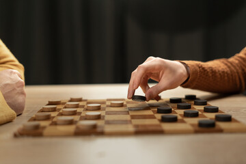 Hands Playing Checkers on Wooden Board, Strategic Game at Home