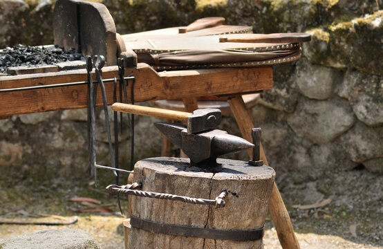 Blacksmith art work tools, hammer, anvil, medieval pliers, heating bench with blower and coal