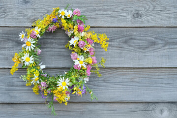 Summer background. wreath of meadow flowers on wooden plank wall. floral crown, traditional...
