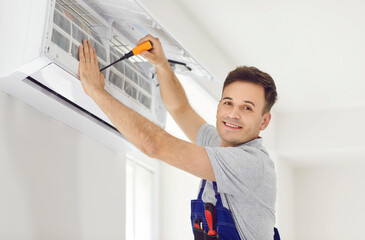 Skilled man, technician or electrician, expertly installing, maintaining, repairing, and cleaning...