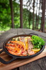 Healthy baked salmon steaks with greens and asparagus in a black cast iron skillet. A delicious low-carb breakfast.