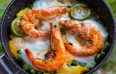 Cooking shrimp with vegetables in a frying pan.