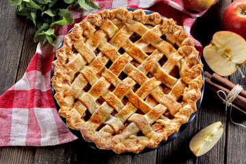 Homemade apple pie with fresh apples on wooden background, top view. Thanksgiving traditional dessert.