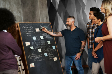 Man, workshop and chalk board in office for training, teaching and learning for skill or career...
