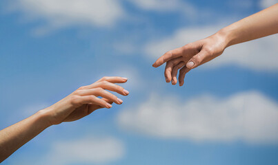 Two woman hands reaching towards each other on isolated sky background. Helping hand outstretched, salvation. Close up help hand. Two hands, helping arm friend, teamwork. Helping hand